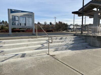 Some stairs leading to the sign identifying the Stanwood Station.